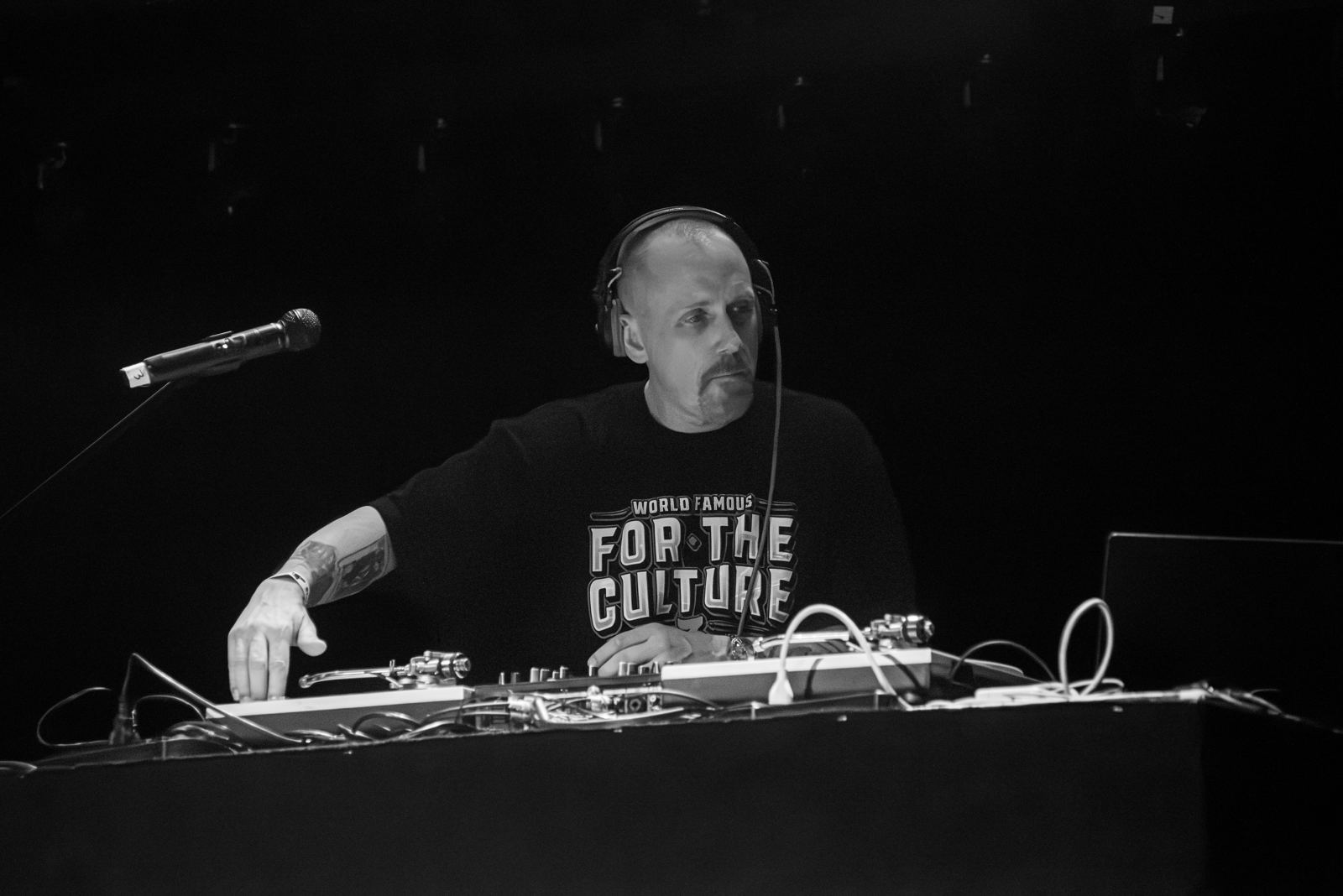 DJ Revolution in headphones at the turntables, black and white